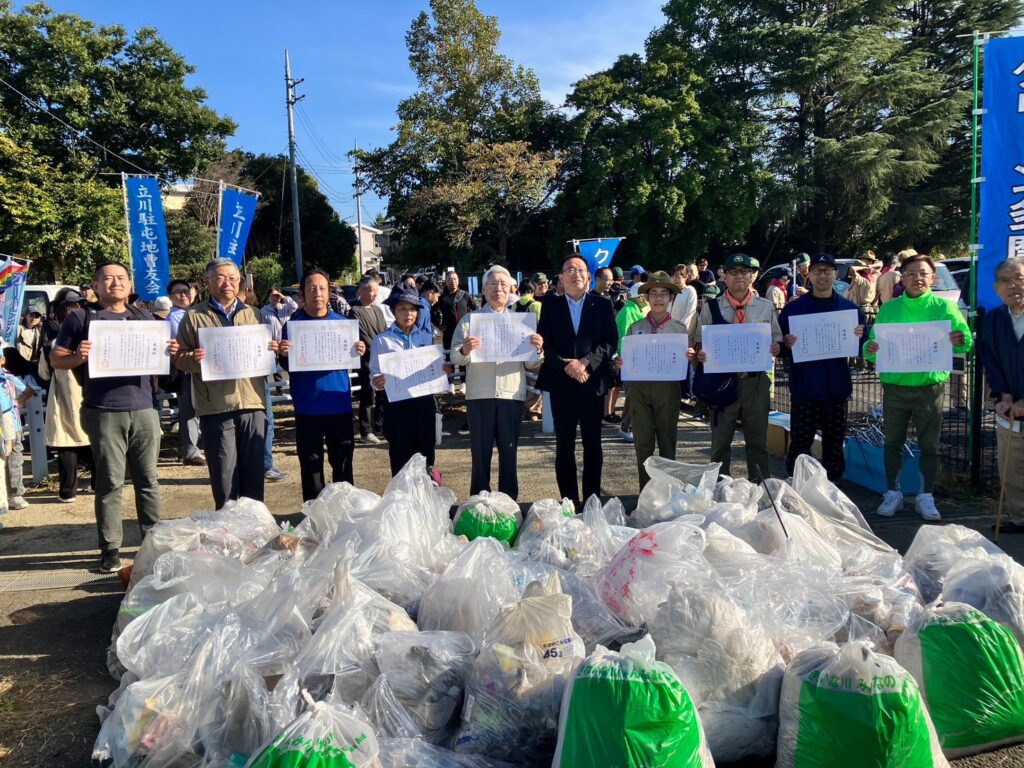 クリーン多摩川60周年記念感謝状を手にした参加者と清掃で集めたごみ